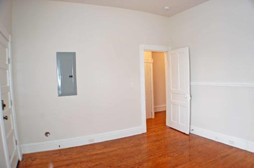A room with a white door and a mirror on the wall.