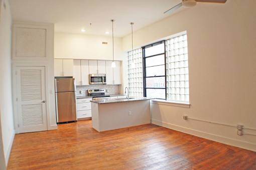 A kitchen with a refrigerator, microwave, and oven.