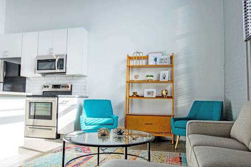 A living room with a glass table and a sofa.