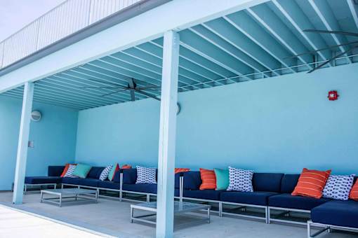 A blue couch with pillows under a white roof.