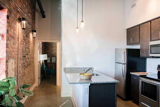 A kitchen with a refrigerator, oven, and microwave.