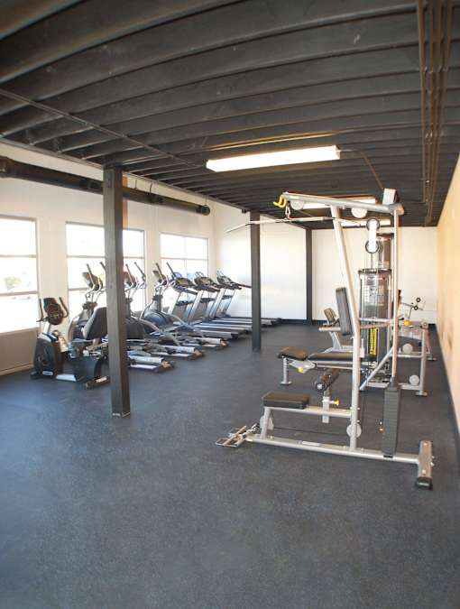 A gym with a variety of equipment including a leg press machine.