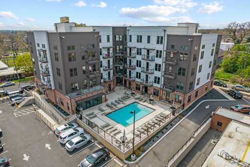 An aerial view of a multi-story apartment complex with a pool.