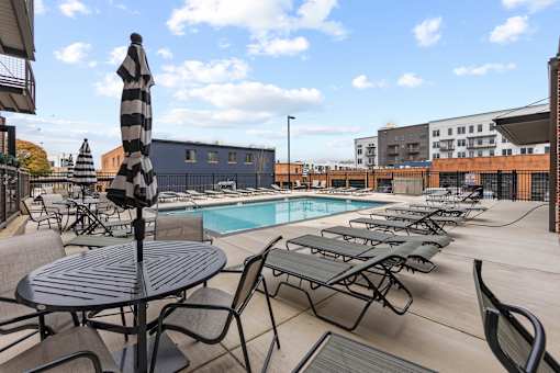 A poolside area with a table and chairs.