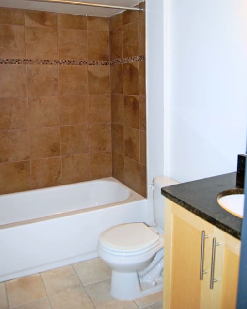 A bathroom with a toilet, tub, and sink.