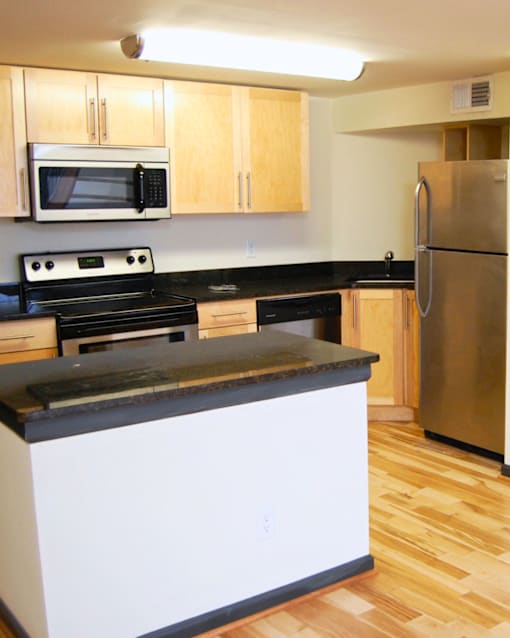 A kitchen with a stove, microwave, and refrigerator.