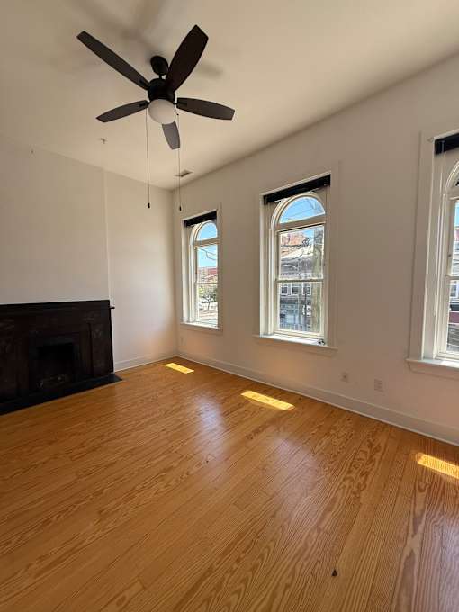 A room with a fireplace and a ceiling fan.