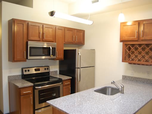 A kitchen with a stove, refrigerator, and microwave.