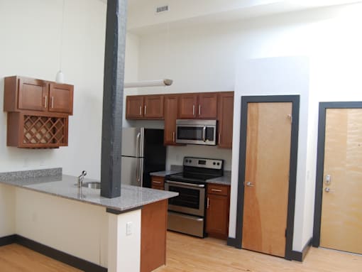 A kitchen with a stove top oven and a refrigerator.