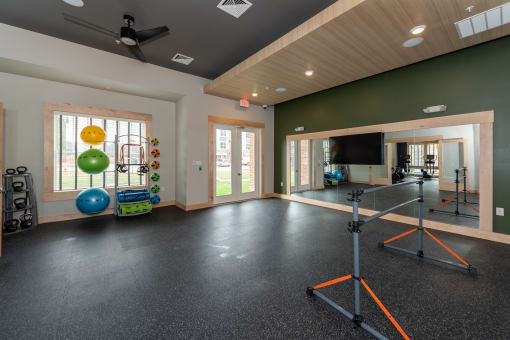 a home gym with a television and exercise equipment at the enclave at woodbridge apartments in sugar at The Bend Arbordale, Williamsburg, Virginia