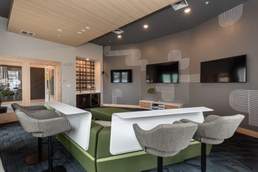 a room with a green sofa and two white tables and chairs at The Bend Arbordale, Williamsburg, VA