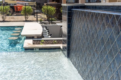 a swimming pool with a retaining wall and a water feature at The Bend Arbordale, Williamsburg