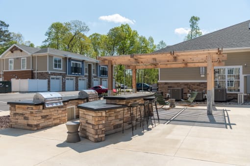 a patio with a bar and a grill in front of a house at The Bend Arbordale, Virginia, 23188