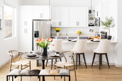 a kitchen and dining area with a table and chairs and a refrigerator at Onyx at Westgate Apartments, Glendale, Arizona