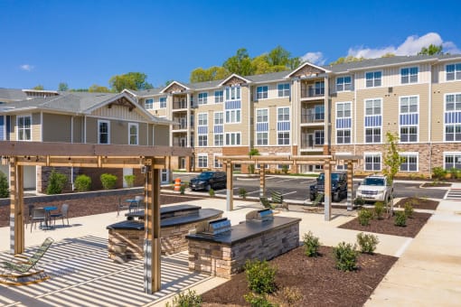 an outdoor patio with a firepit and picnic table at the enclave at woodbridge apartments in at The Bend Arbordale, Williamsburg