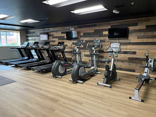 A gym with treadmills, exercise bikes, and elliptical machines.