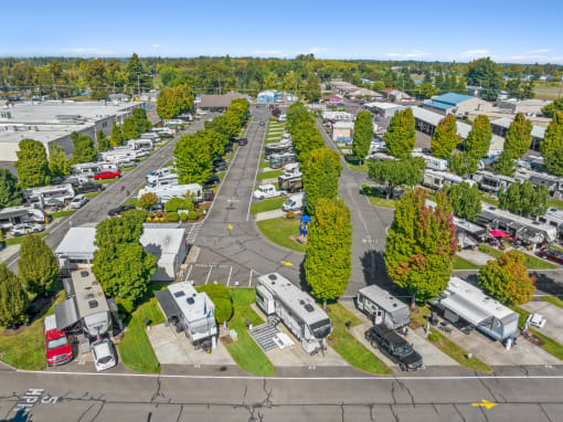an aerial view of a parking lot with rvs and trees