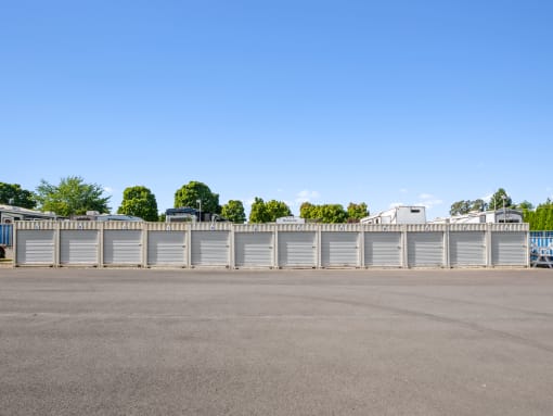 an empty parking lot with a white fence