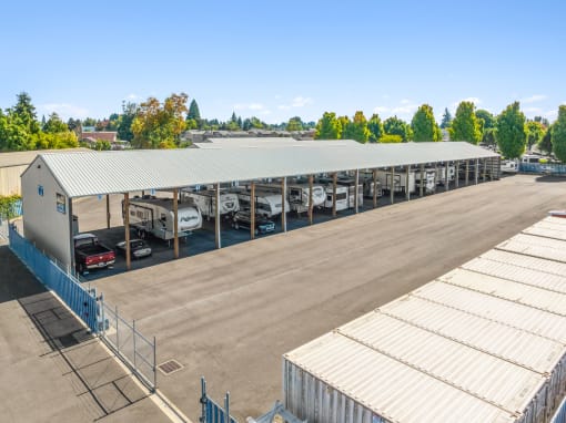 a parking lot filled with cars and a building with a roof