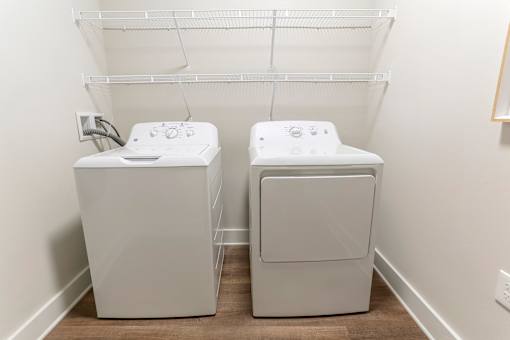 a washer and dryer in a room with a white wall and wood floor at Annandale Apartment Homes, Tennessee 37128