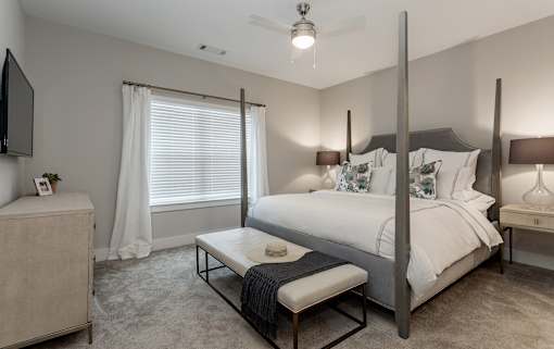 a bedroom with a bed and a table in front of a window at Annandale Apartment Homes, Murfreesboro, 37128