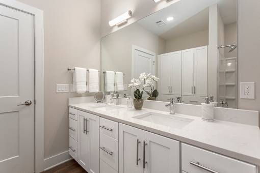 a white bathroom with two sinks and a mirror at Annandale Apartment Homes, Murfreesboro, Tennessee