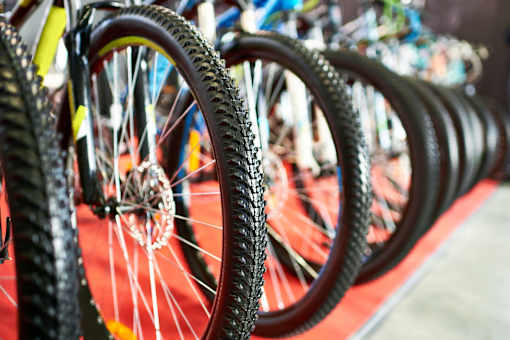 a row of bicycle wheels with tires on a red rug