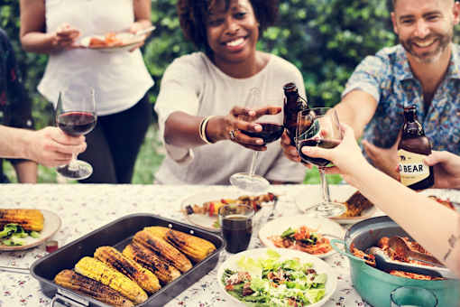 people sitting around a table drinking wine and eating food