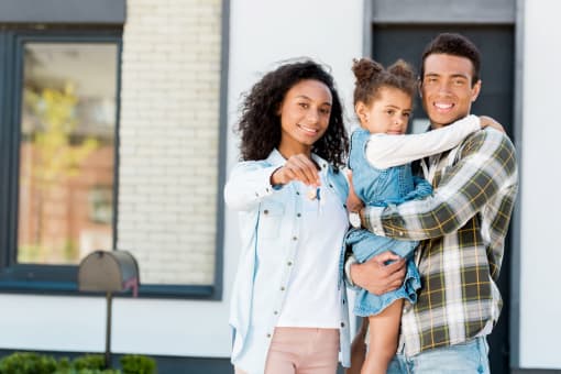 A family of three standing in front of a house at Countryside River, Wilmington, 60402