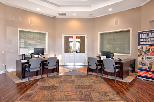 a room with a table and chairs with computers on top of it
