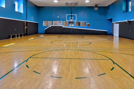 an indoor basketball court with a basketball hoop in the middle
