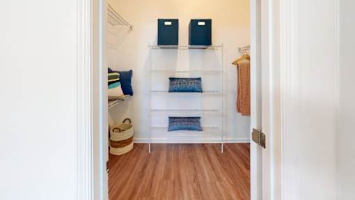 A white hallway with a shelf and two speakers on top.