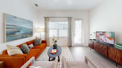 A living room with a couch, a coffee table, and a painting on the wall.