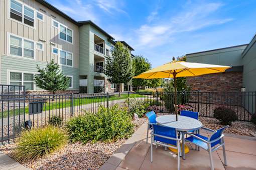 Table and Chairs with a Yellow Umbrella at WestLink at Oak Station Apartments, Colorado, 80215