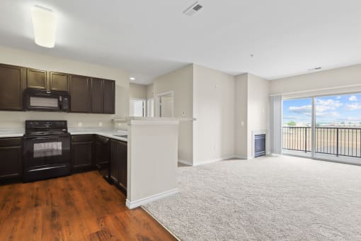 a kitchen and living room with a balcony