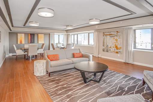 a living room and dining room with couches and a table at 10 West Apartments, Long Beach, NY