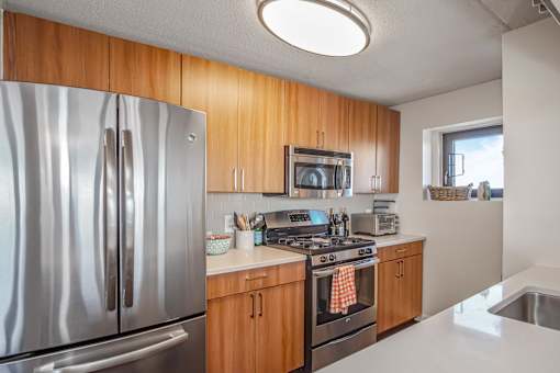 kitchen with brown cabinets at 10 West Apartments, New York 11561