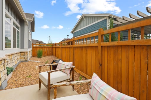 a backyard with a wooden fence and patio furniture at The Villas at Prairie Center, Brighton, 80601