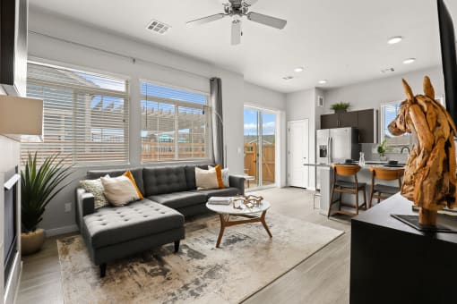 a living room with a couch and a coffee table in front of a window at The Villas at Prairie Center, Brighton, CO, 80601