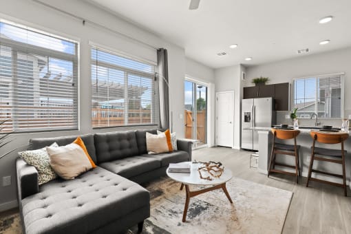 a living room with a couch coffee table and a kitchen in the background at The Villas at Prairie Center, Colorado