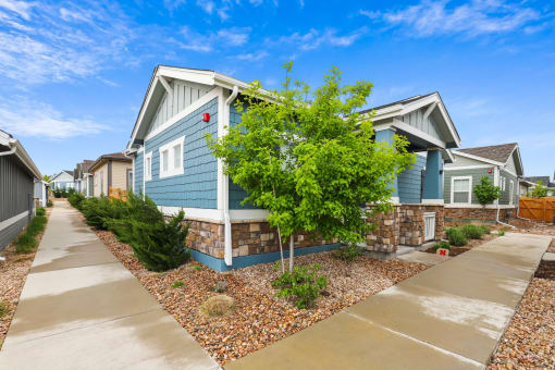 a blue house with a blue sky in the background at The Villas at Prairie Center, Brighton, CO
