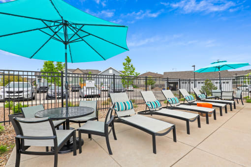 the reserve at bucklin hill patio with umbrellas and chairs at The Villas at Prairie Center, Brighton, Colorado