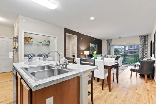 a kitchen and living room with a wooden floor and a large window