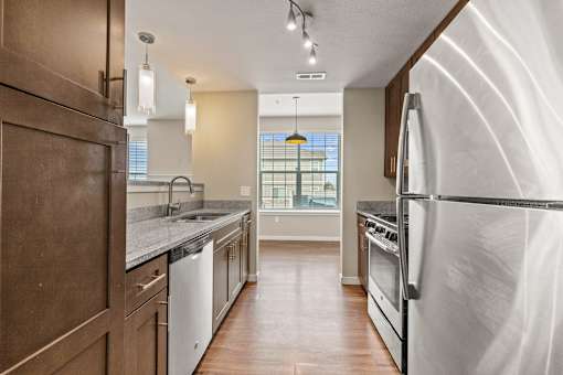 a kitchen with white appliances and a large window