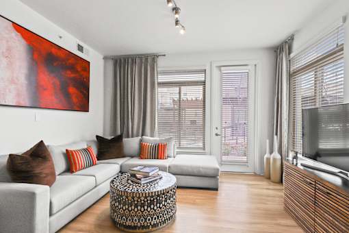 a living room with a white couch and a large red painting on the wall at 8000 Uptown Apartments, Colorado