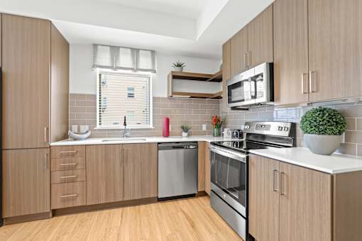 a kitchen with wooden cabinets and white countertops at 8000 Uptown Apartments, Broomfield