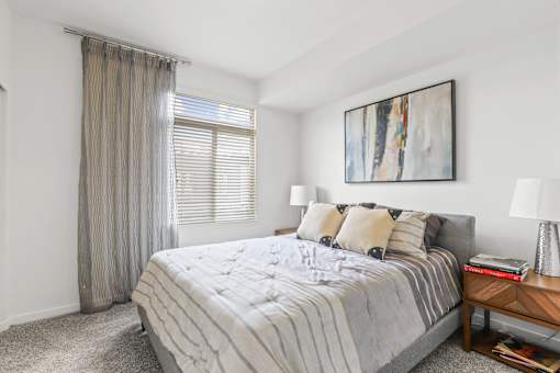 a bedroom with a large bed and a large window at 8000 Uptown Apartments, Broomfield, CO, 80021