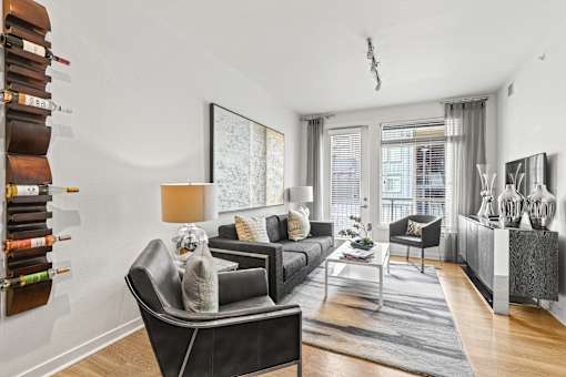 a living room with white walls and hardwood floors at 8000 Uptown Apartments, Colorado 80021
