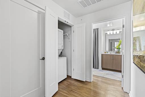 a bedroom with a medium hardwood floor and white walls at 8000 Uptown Apartments, Colorado