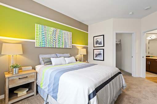 a bedroom with a large bed and a bathroom in the background